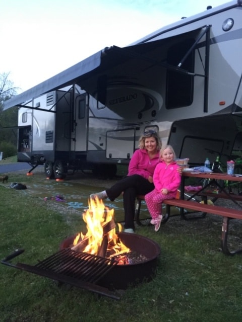Woman And Girl Sitting Around Campfire RV Travel Guide