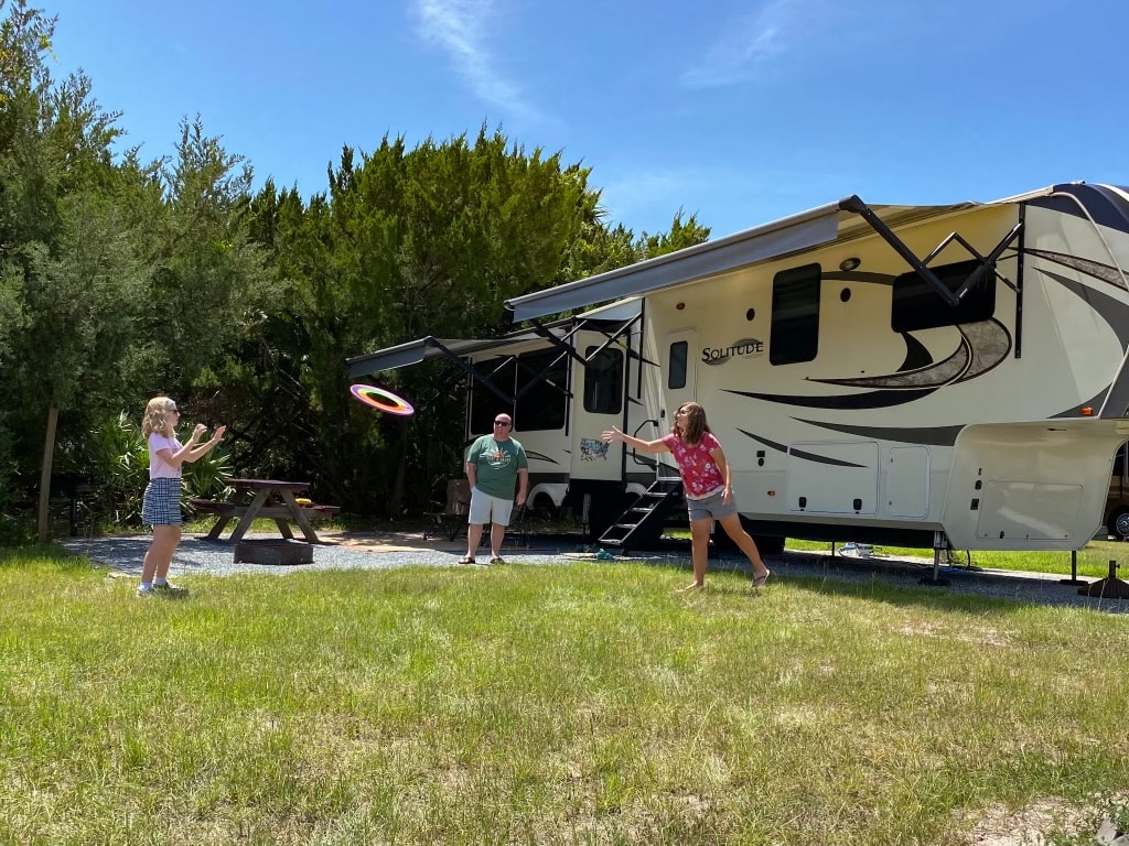Family playing catch in RV campsite - RV Living Full Time