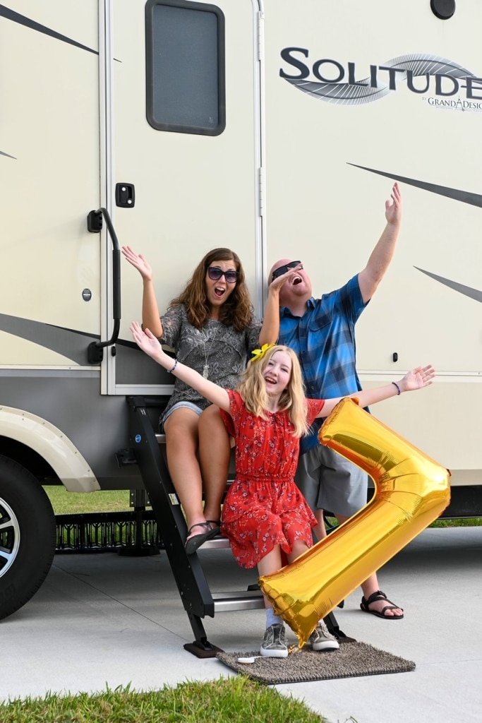 Family In Front Of RV Celebrating 7 Years Of Camper Life