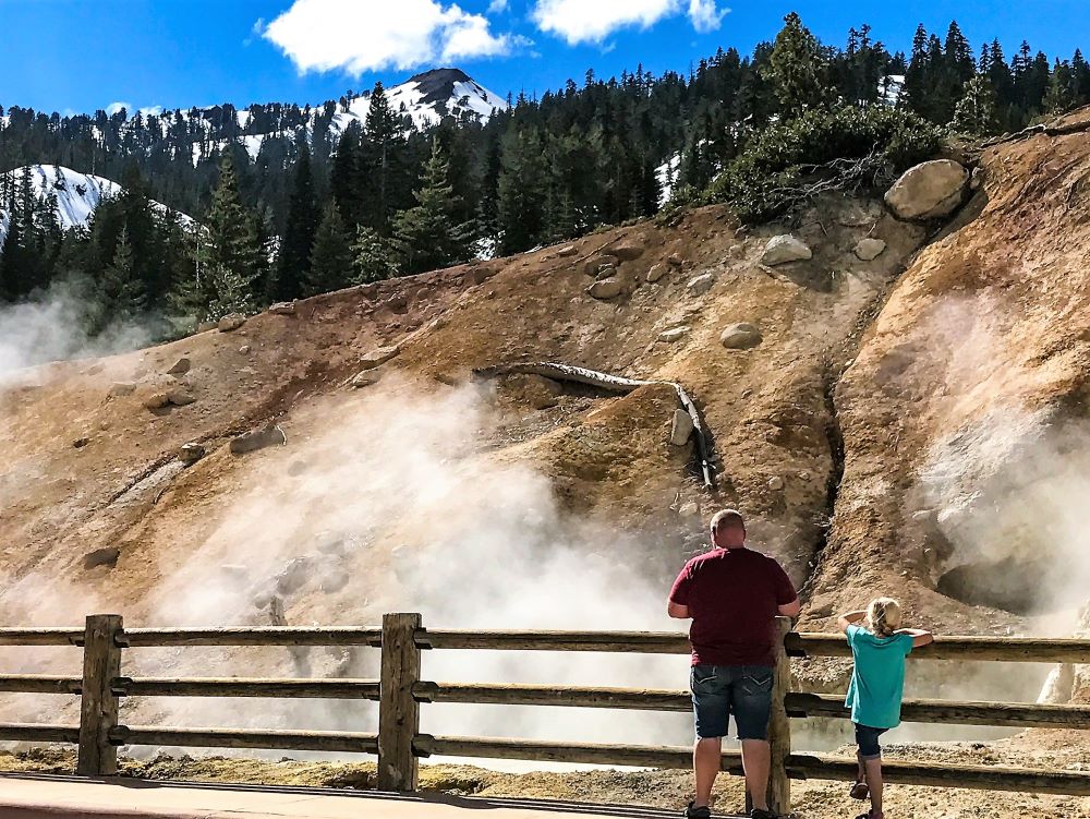 Man and girl viewing bubbling mud pots in Lassen National Park