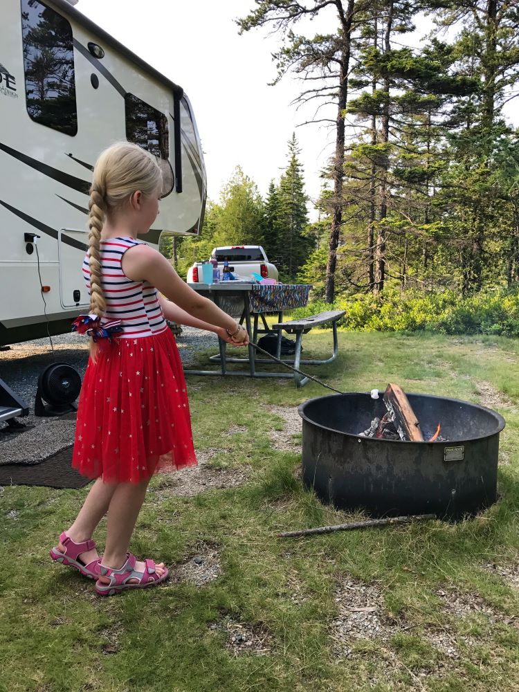 Girl roasting marshmallows in RV campsite