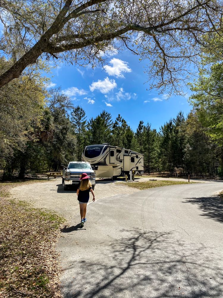 Girl walking into RV campsite in state park - full time family RVing